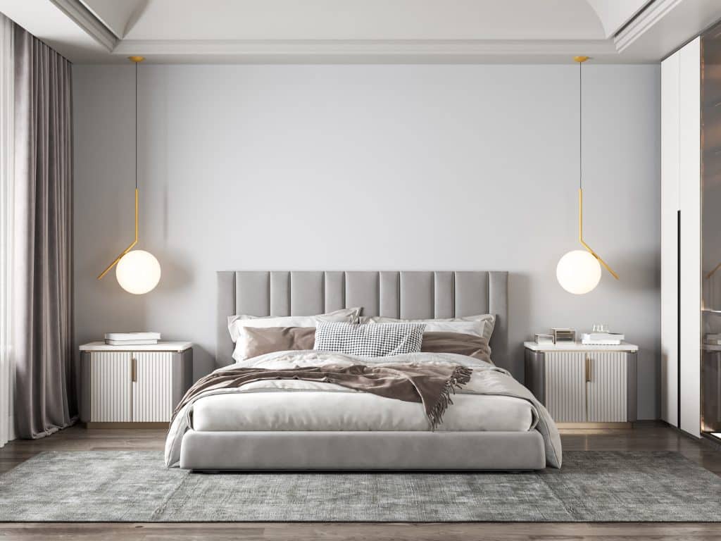 bedroom with grey fabric bedframe and neutral bedsheets
