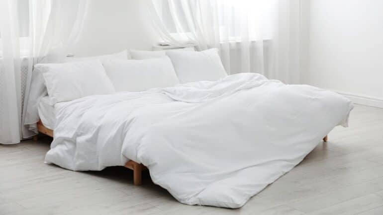 white sheets and bedding on bed