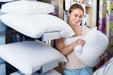 woman in store weighing pillow options