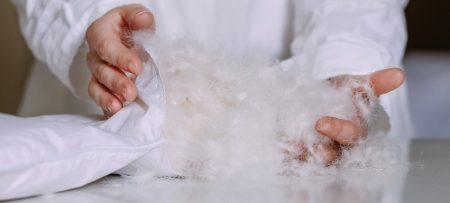 closeup on a woman's hands as she fills a pillow with polyfill