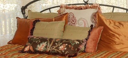 Throw pillows in fall colors on a bed