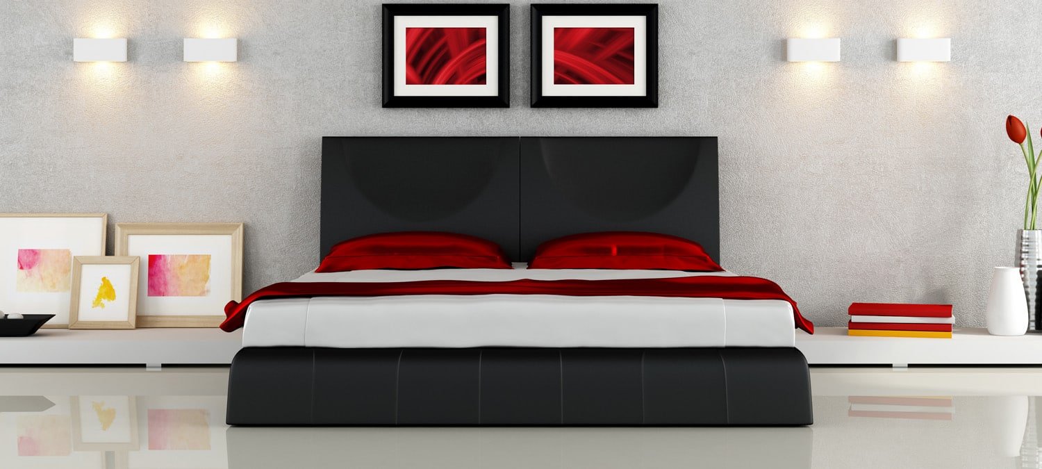 sleek modern bedroom with black platform bed frame, red pillows, and red room accents